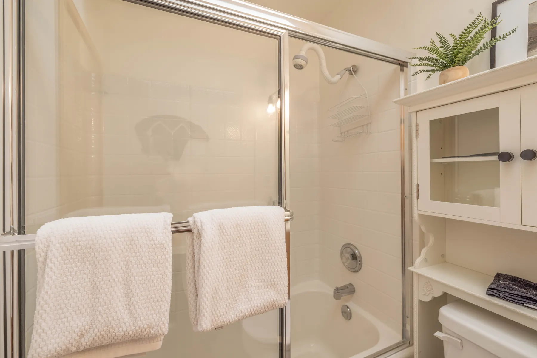 Bathroom Two at Pine Grove Cabin showing the tub/shower combo with glass sliding doors