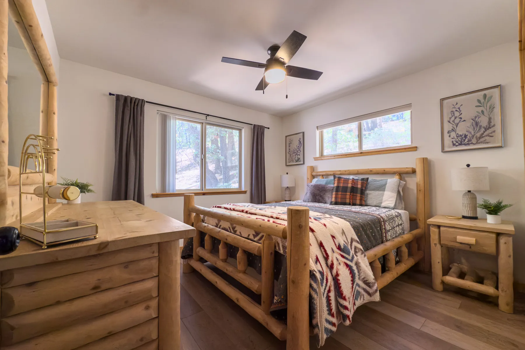 Bedroom Two at Pine Grove Cabin with a queen log bed, mountain-pattern bedding, and forest-view windows