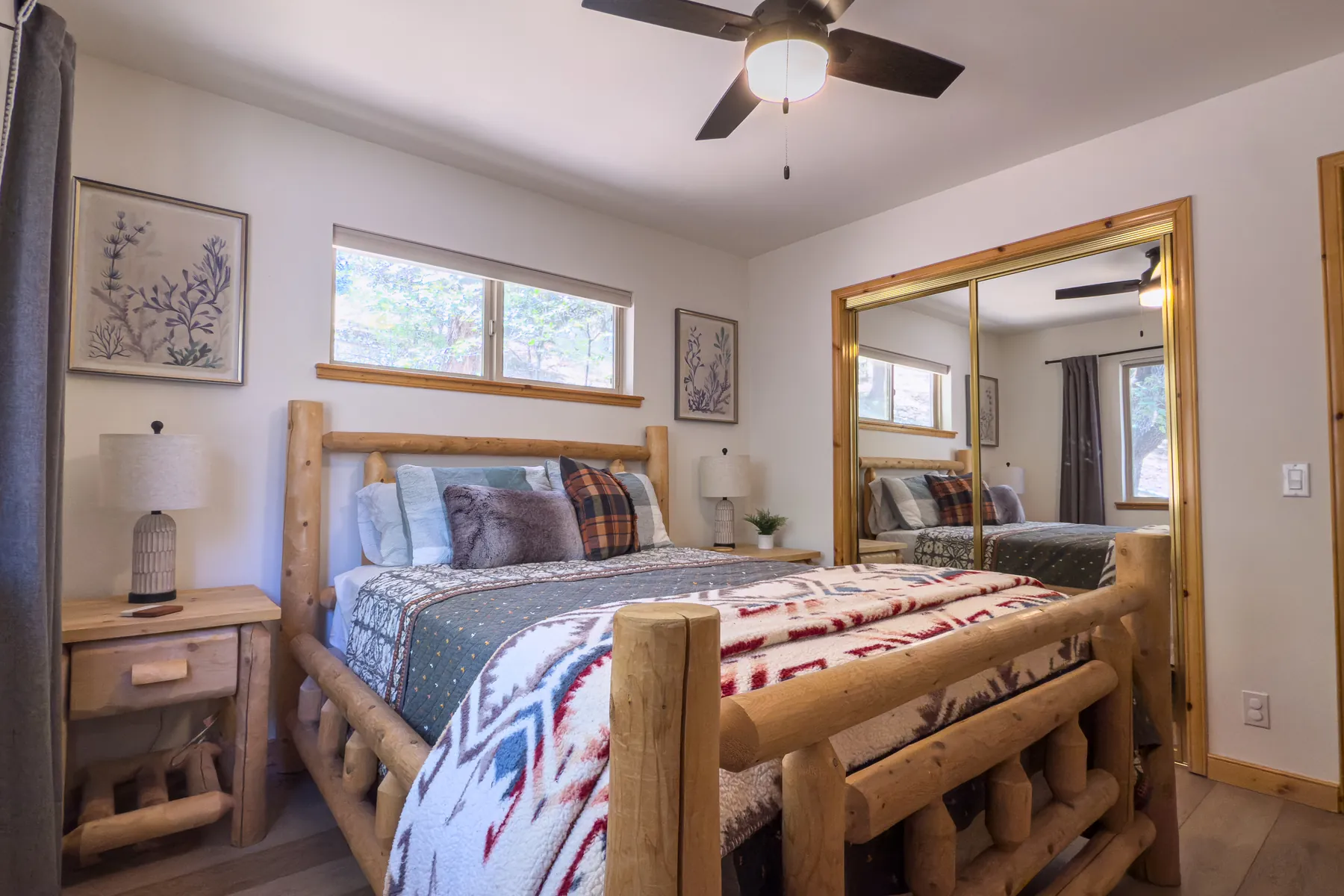 Bedroom Two at Pine Grove Cabin showing the queen log bed, bedside tables, and mirrored closet doors