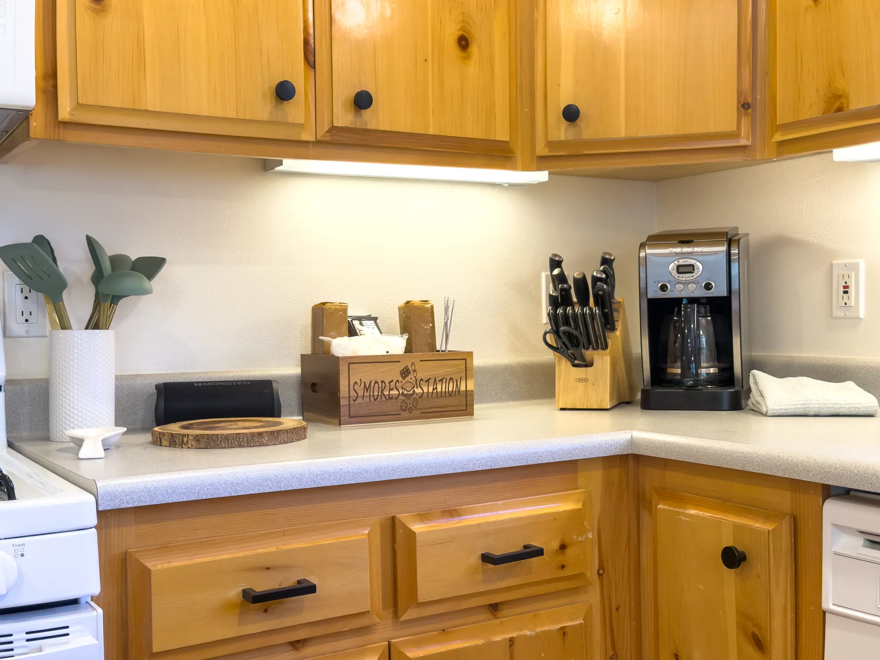 Kitchen counter at Pine Grove Cabin with a s'mores station, coffee maker, and knife block